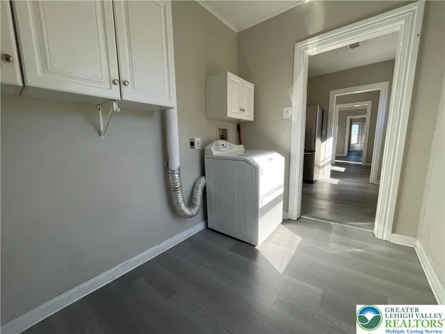 a utility room with wooden floor washer and dryer
