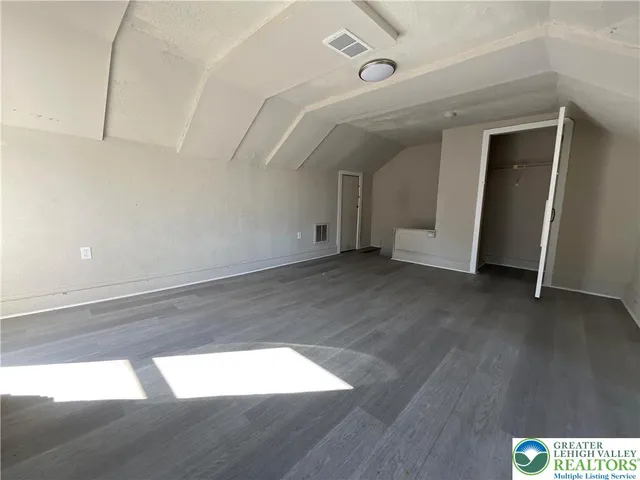 a view of an empty room with wooden floor