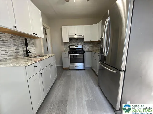 a kitchen with stainless steel appliances a refrigerator sink and cabinets