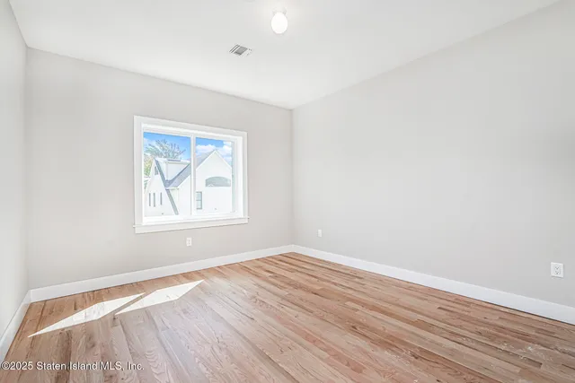 an empty room with wooden floor and a window