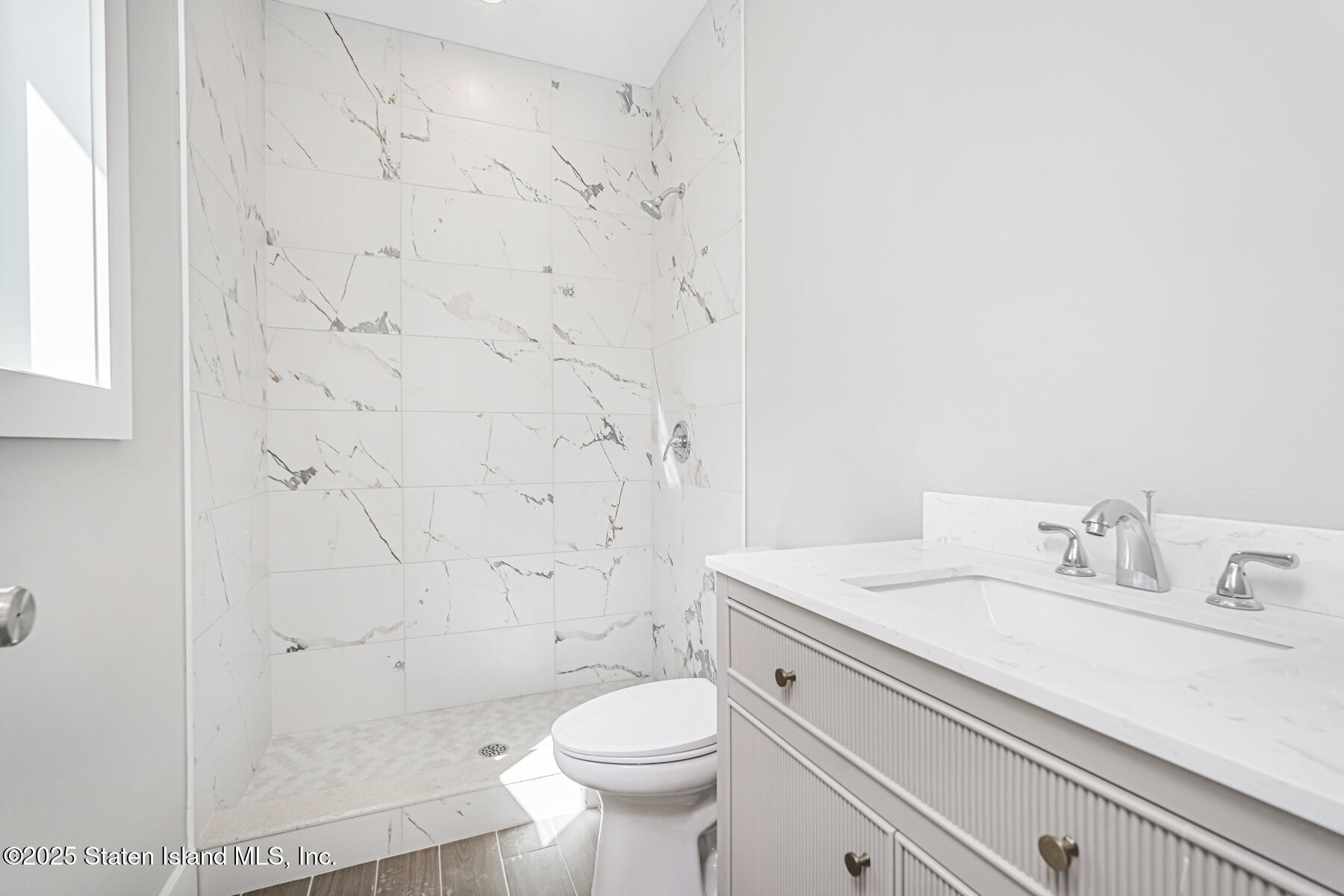 291 Rensselaer Avenue Staten Island, NY 10312 - Photo 16 of 38 a bathroom with a sink a toilet and shower