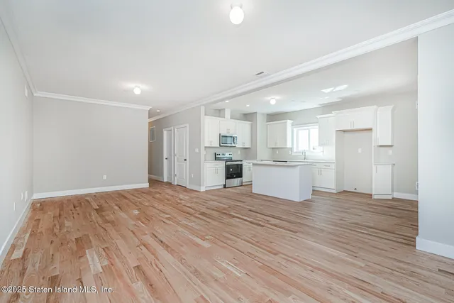 a view of a kitchen with wooden floor and a window