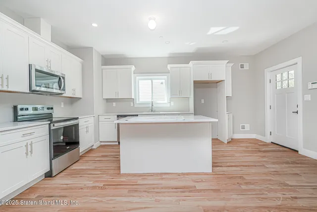 a kitchen with granite countertop a stove top oven and cabinets