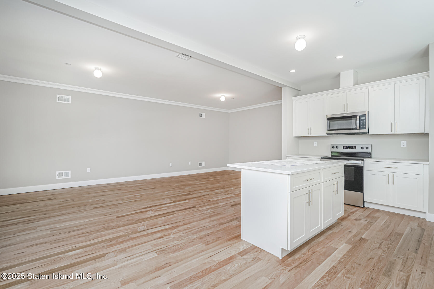291 Rensselaer Avenue Staten Island, NY 10312 - Photo 20 of 38 a kitchen with stainless steel appliances a white stove top oven and white cabinets