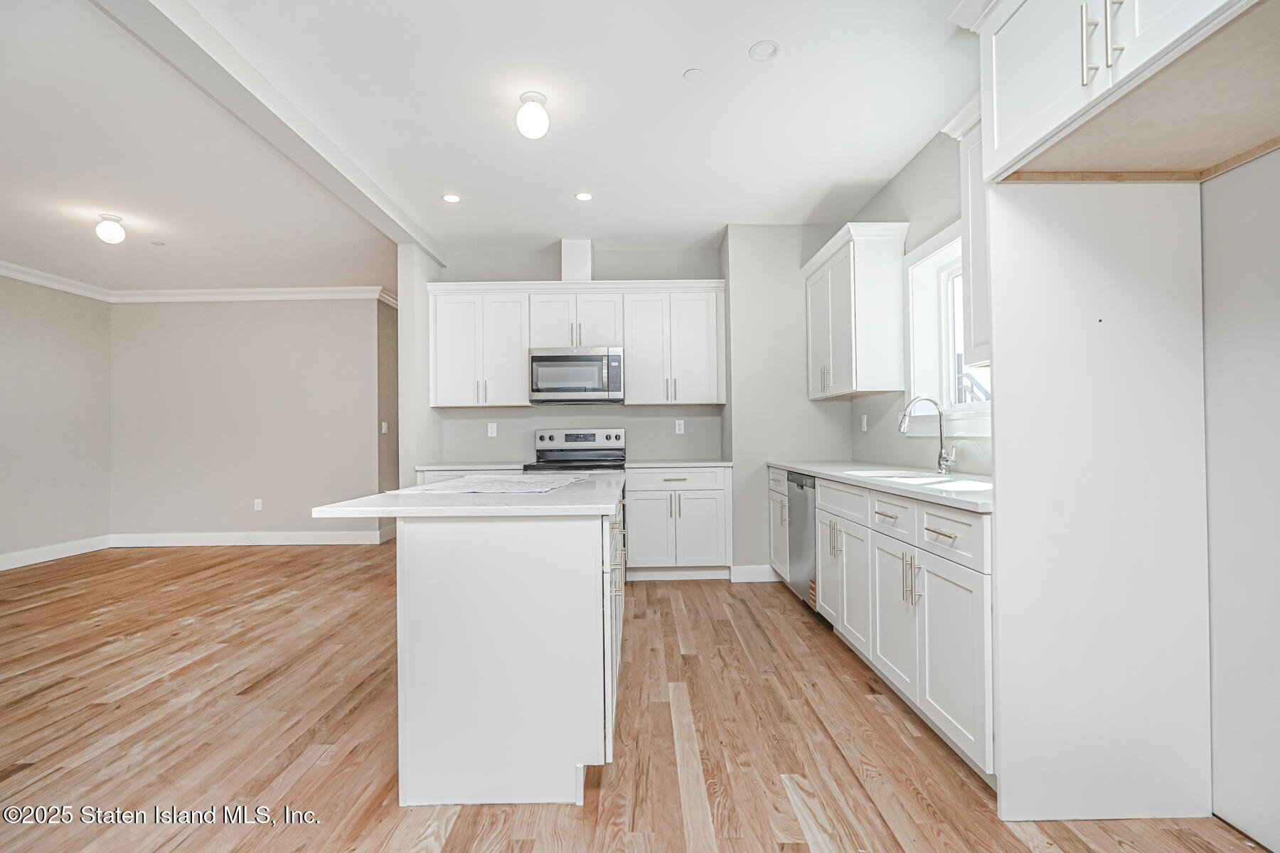 291 Rensselaer Avenue Staten Island, NY 10312 - Photo 21 of 38 a kitchen with wooden floor sink and white appliances