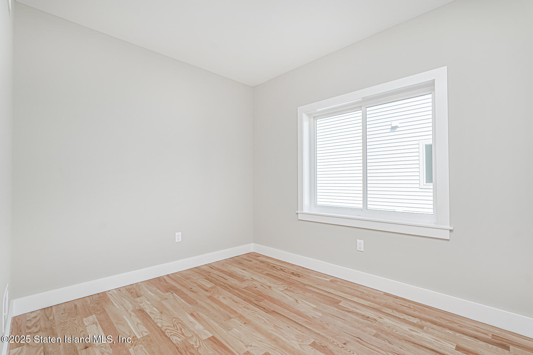 291 Rensselaer Avenue Staten Island, NY 10312 - Photo 26 of 38 an empty room with wooden floor and windows