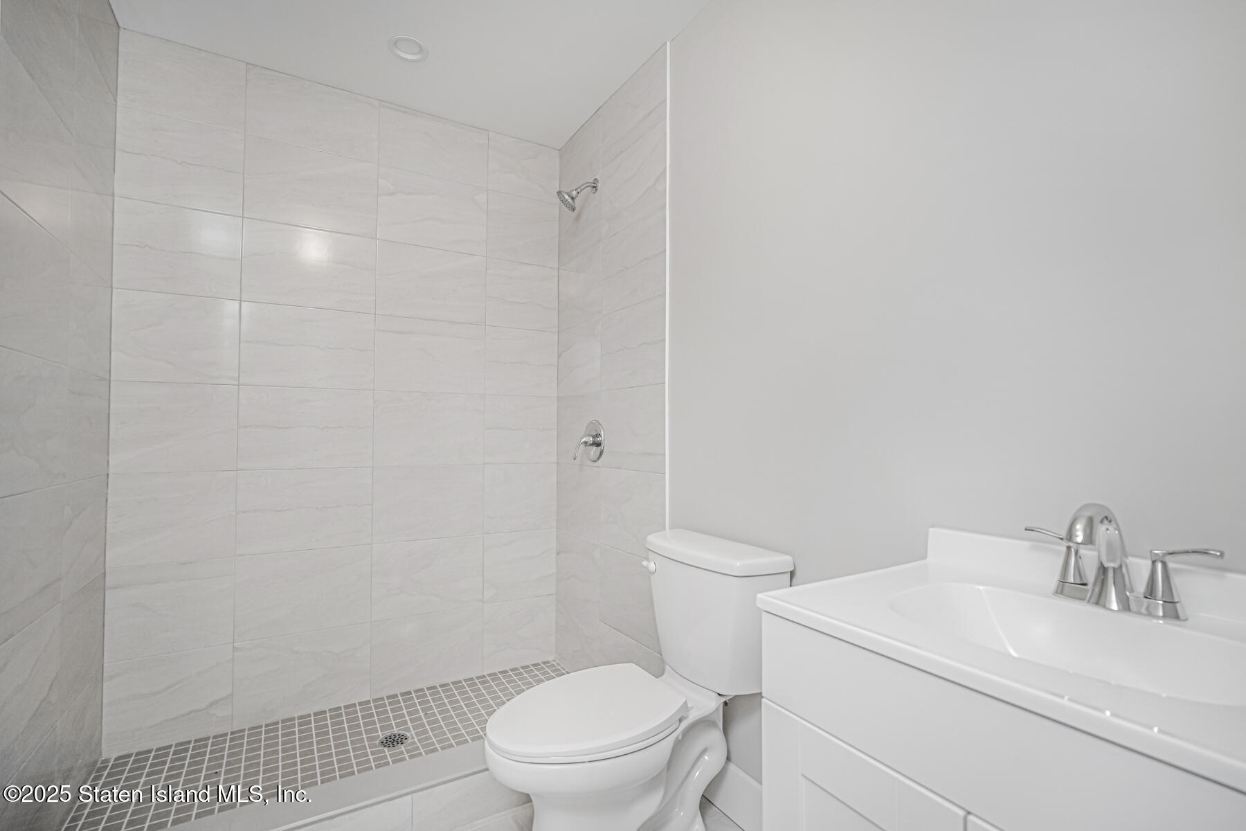 291 Rensselaer Avenue Staten Island, NY 10312 - Photo 34 of 38 a white toilet sitting next to a bathroom sink