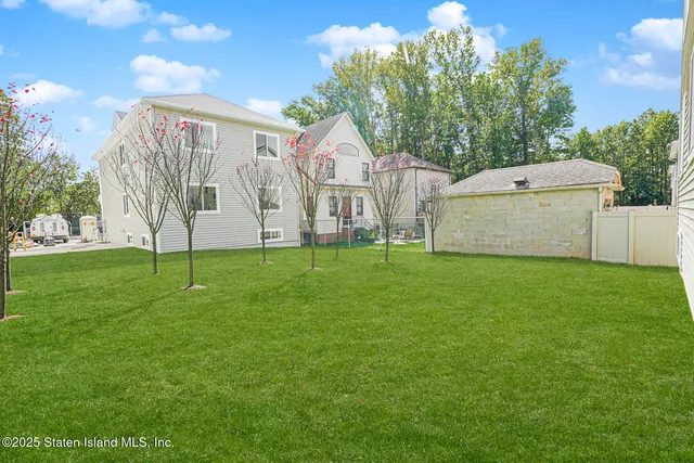 a view of a house with a yard and a tree