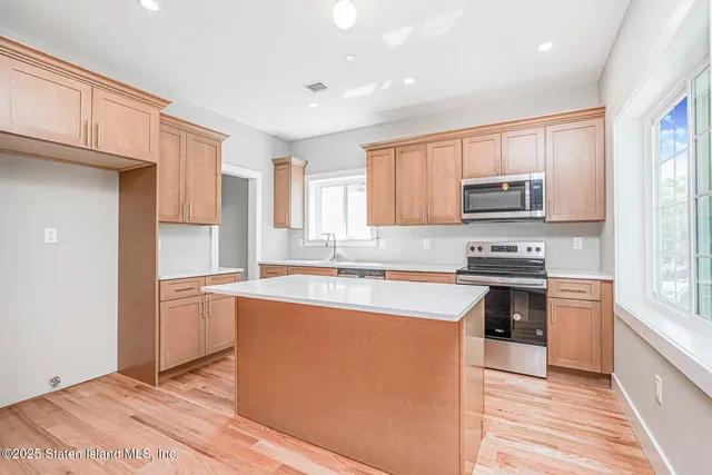 a kitchen with stainless steel appliances granite countertop a stove a sink and a refrigerator