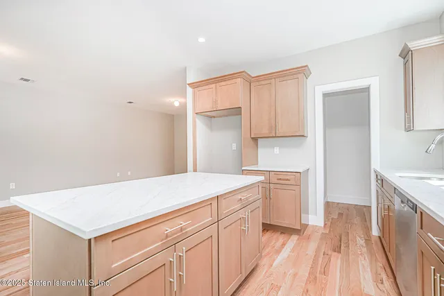 a kitchen that has a sink a stove and wooden floor