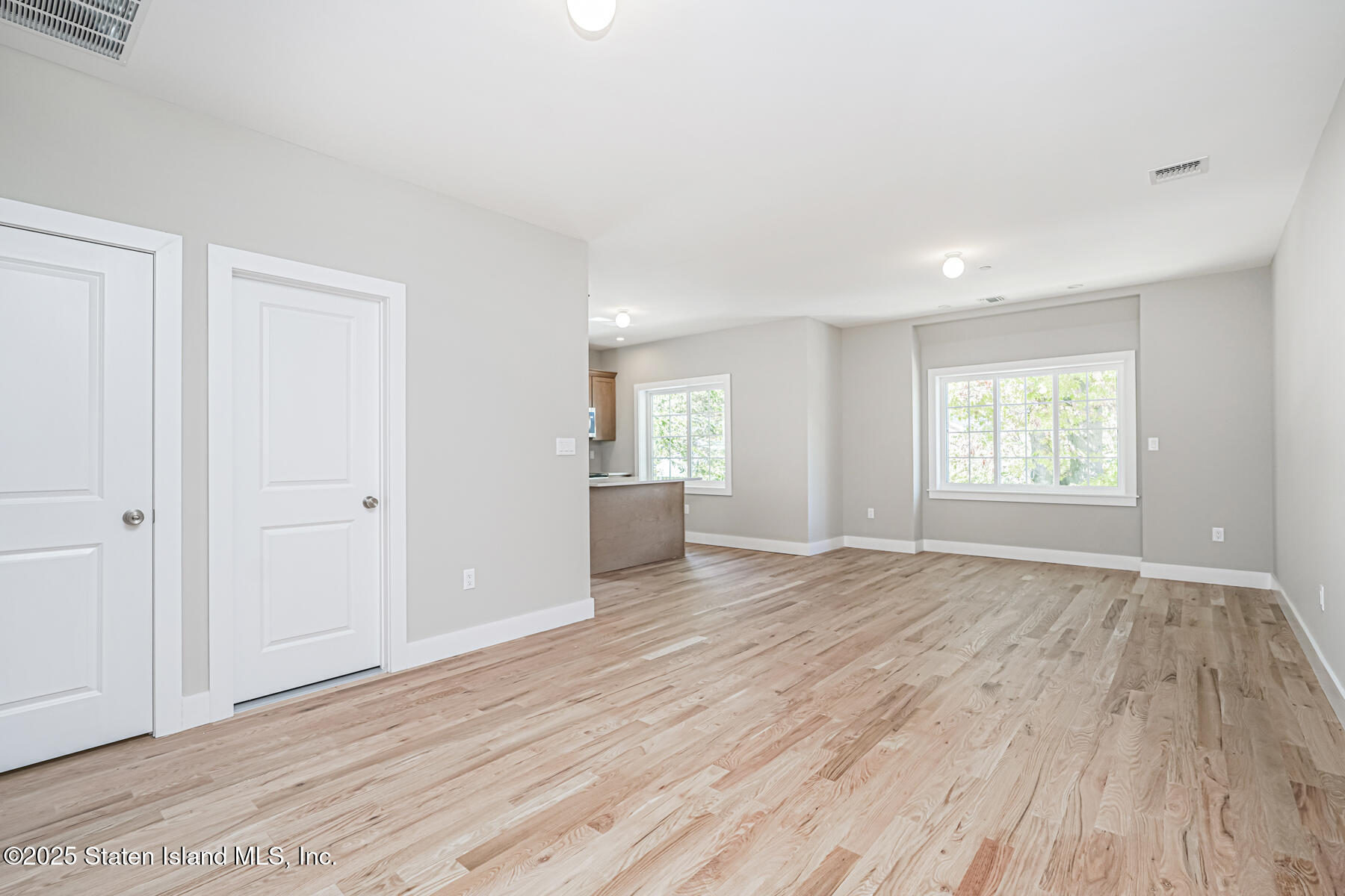 291 Rensselaer Avenue Staten Island, NY 10312 - Photo 9 of 38 wooden floor in an empty room with a window