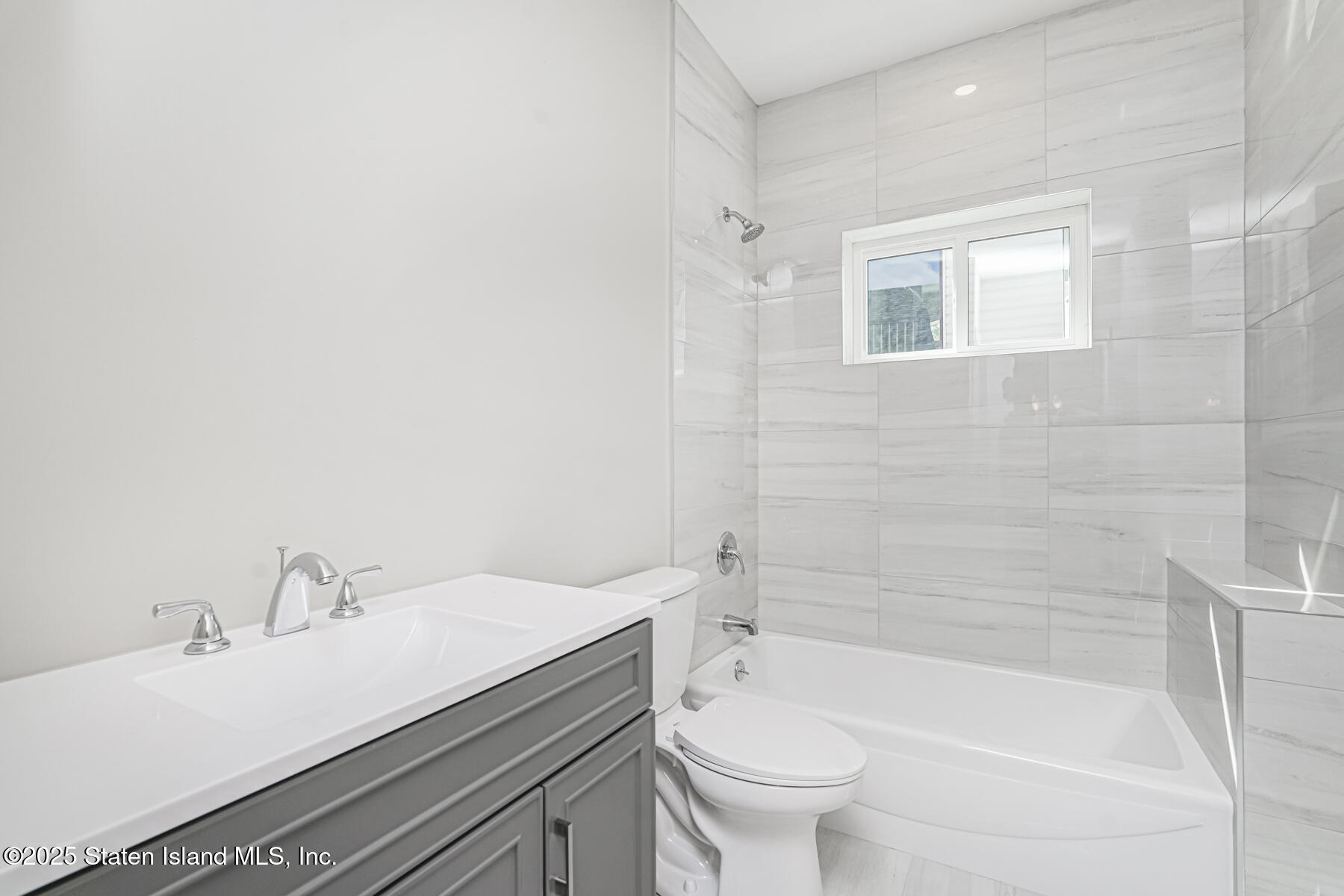 291 Rensselaer Avenue Staten Island, NY 10312 - Photo 10 of 38 a bathroom with a sink a toilet and bathtub