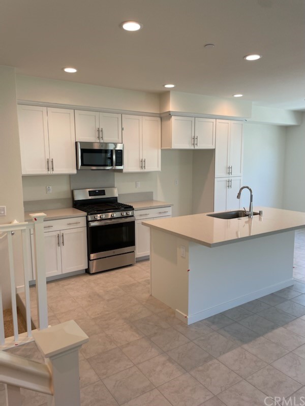 208 Winterbrook Lake Forest, CA 92610 - Photo 2 of 5 a kitchen with kitchen island a sink a stove a microwave a counter top space and cabinets