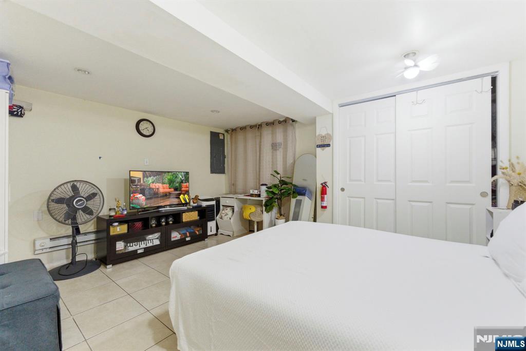 270 Westervelt Place Lodi, NJ 07644 - Photo 9 of 17 a bedroom with a bed a dresser and potted plants