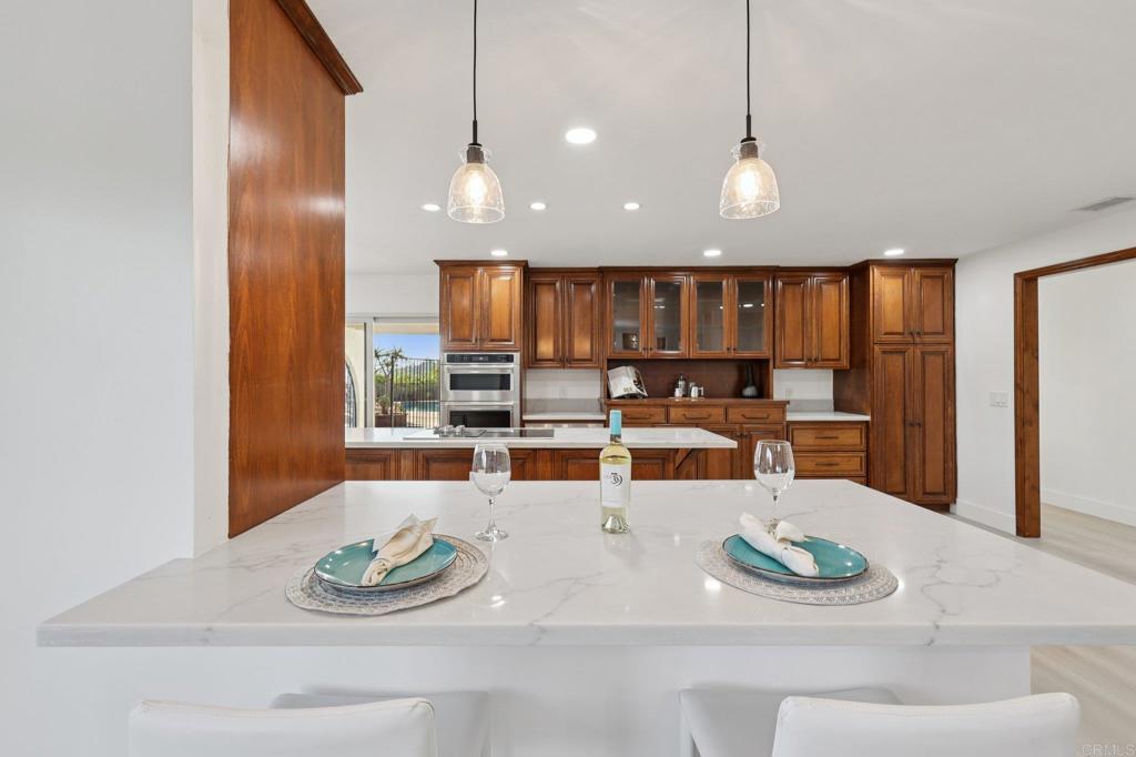 2865 Via Dieguenos Alpine, CA 91901 - Photo 19 of 75 a kitchen with stainless steel appliances kitchen island granite countertop a table and chairs