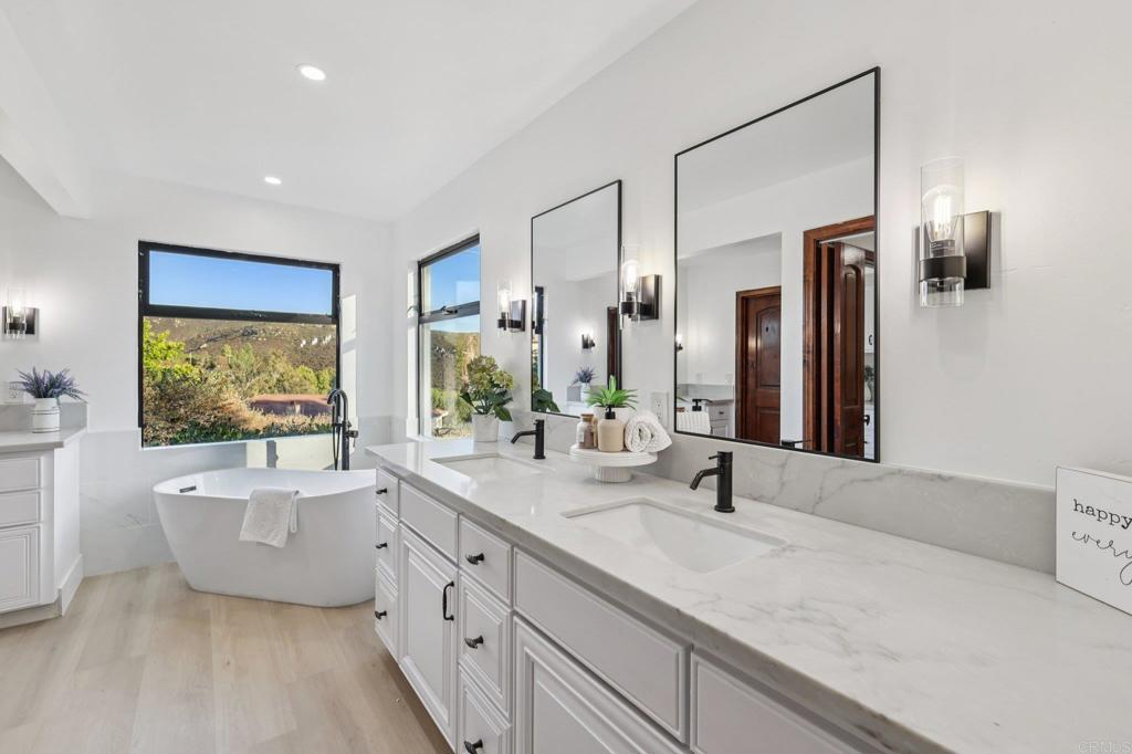 2865 Via Dieguenos Alpine, CA 91901 - Photo 34 of 75 a bathroom with a double vanity sink a mirror and a bathtub