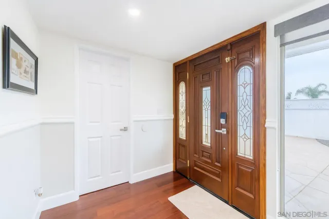 a kitchen with stainless steel appliances kitchen island granite countertop a table chairs and a wooden floors