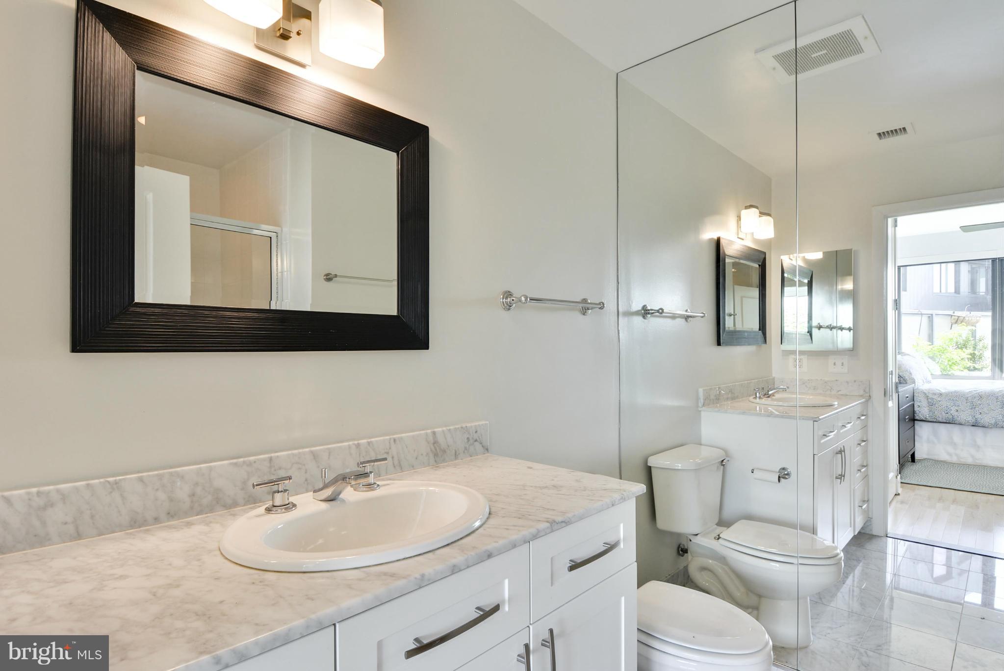 4101 Albemarle Street Northwest, Unit 337 Washington, DC 20016 - Photo 14 of 30 a bathroom with a toilet a sink and mirror