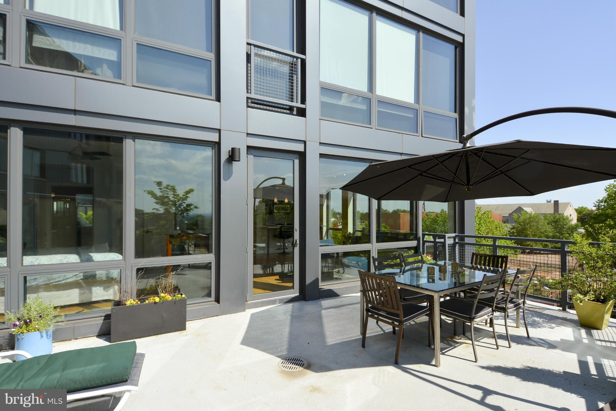 4101 Albemarle Street Northwest, Unit 337 Washington, DC 20016 - Photo 19 of 30 a view of a patio with table and chairs under an umbrella