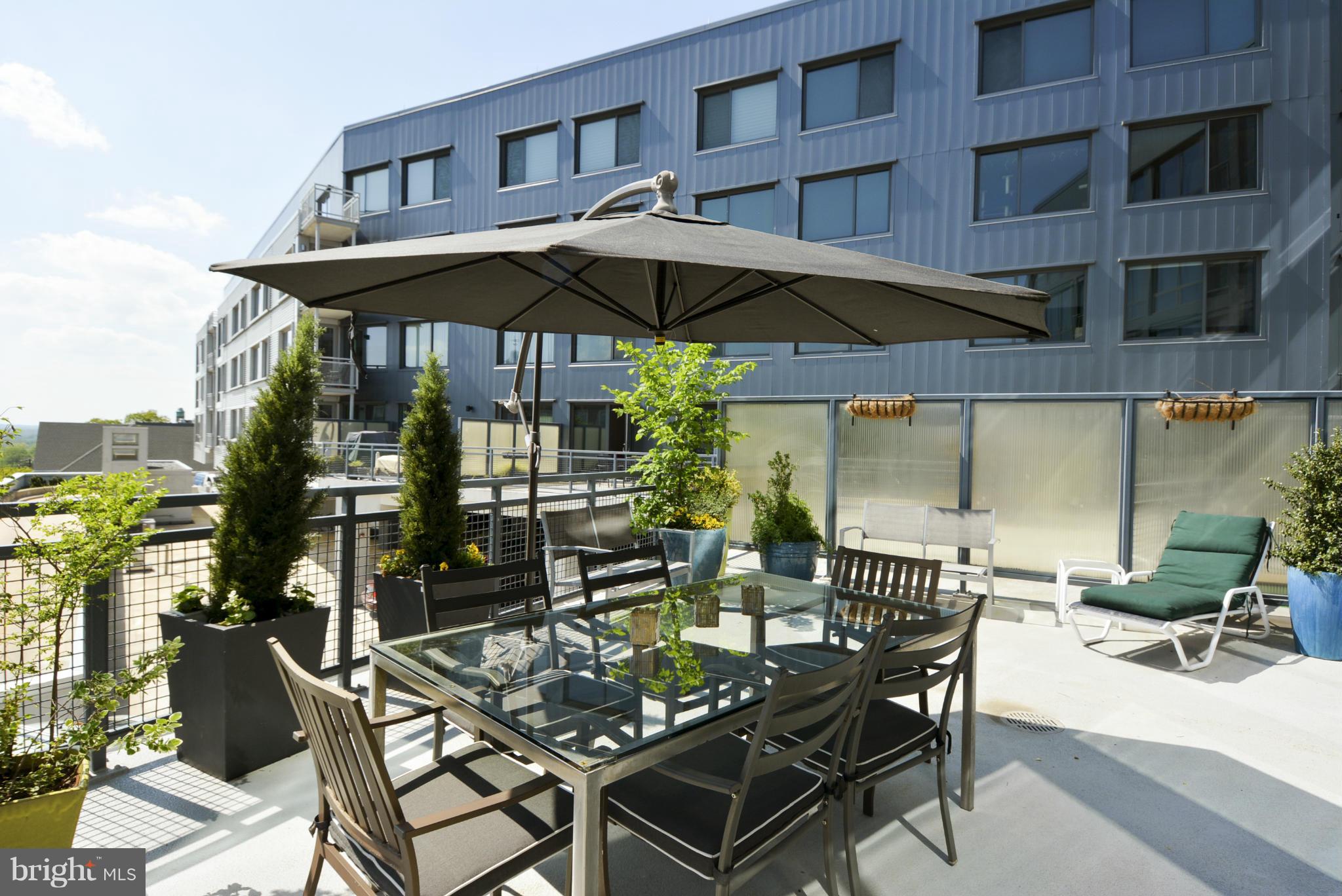 4101 Albemarle Street Northwest, Unit 337 Washington, DC 20016 - Photo 20 of 30 a view of a patio with furniture and table under an umbrella