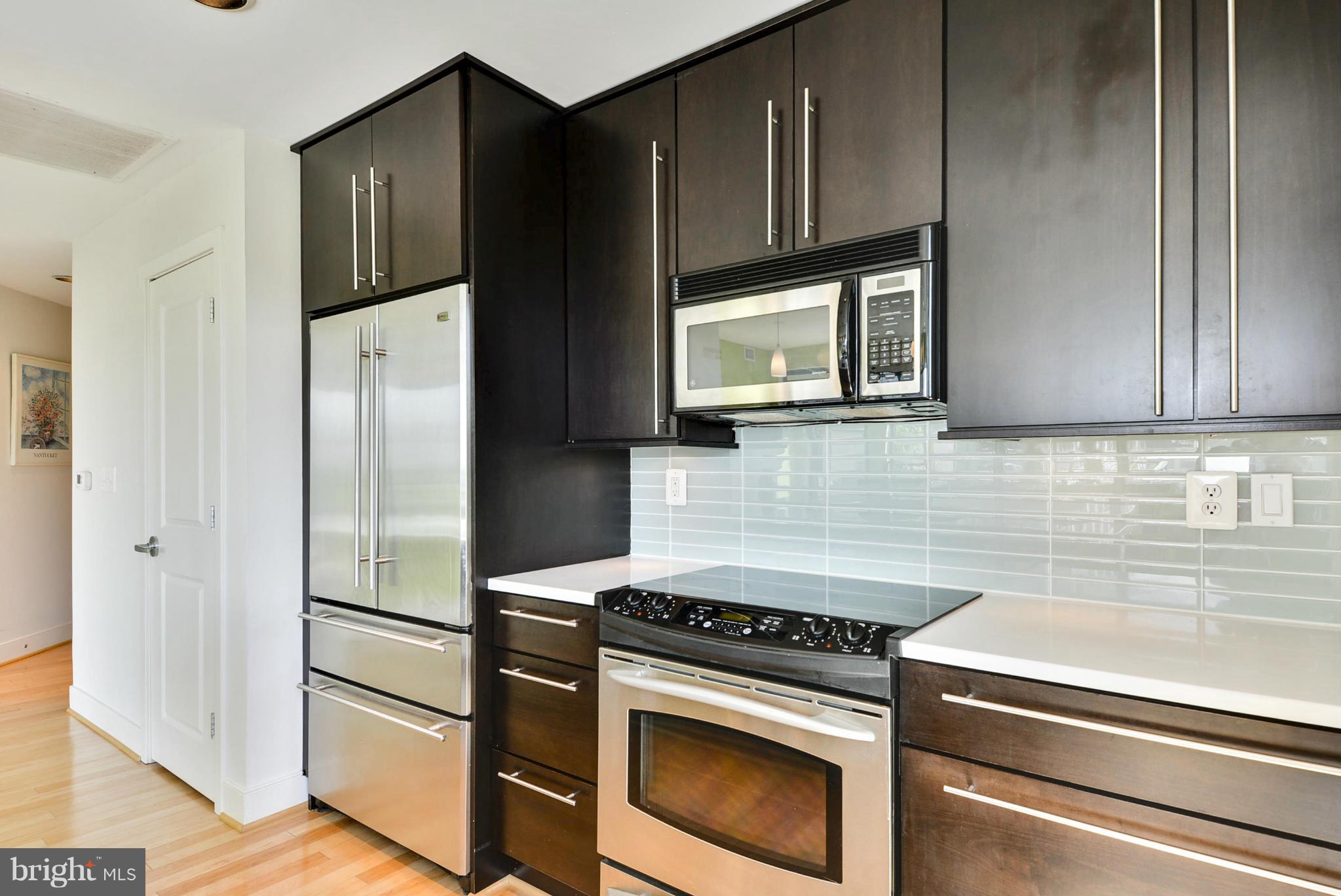 4101 Albemarle Street Northwest, Unit 337 Washington, DC 20016 - Photo 8 of 30 a kitchen with stainless steel appliances granite countertop a refrigerator stove and microwave