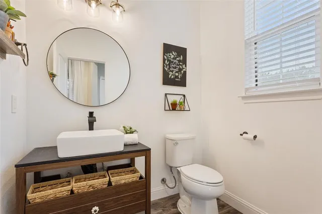 a bathroom with a sink mirror and toilet