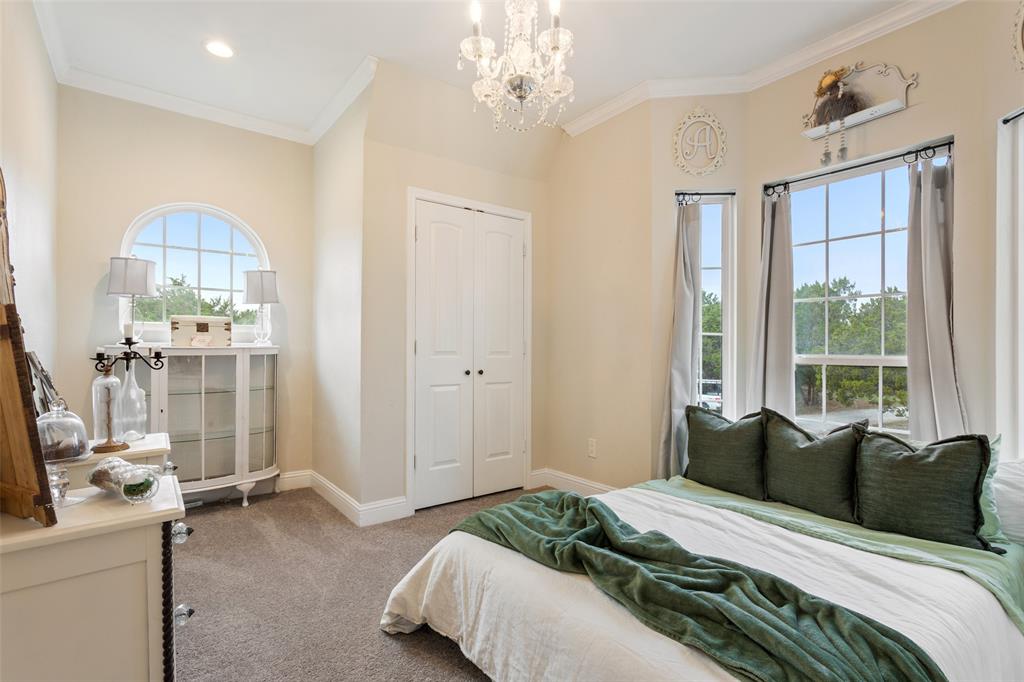 566 Benevolence Way China Spring, TX 76633 - Photo 24 of 35 a bedroom with a bed and a chandelier