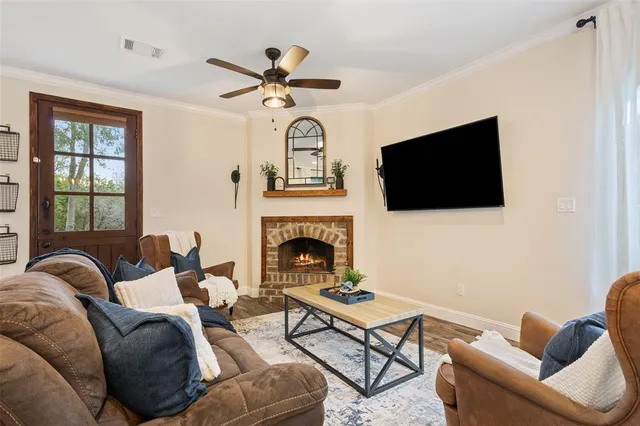 a living room with furniture a flat screen tv and a fireplace