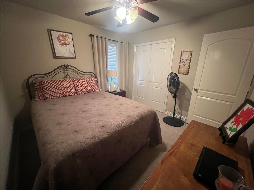 312 McAfee Street Mabank, TX 75147 - Photo 25 of 40 a bedroom with a bed and a chandelier