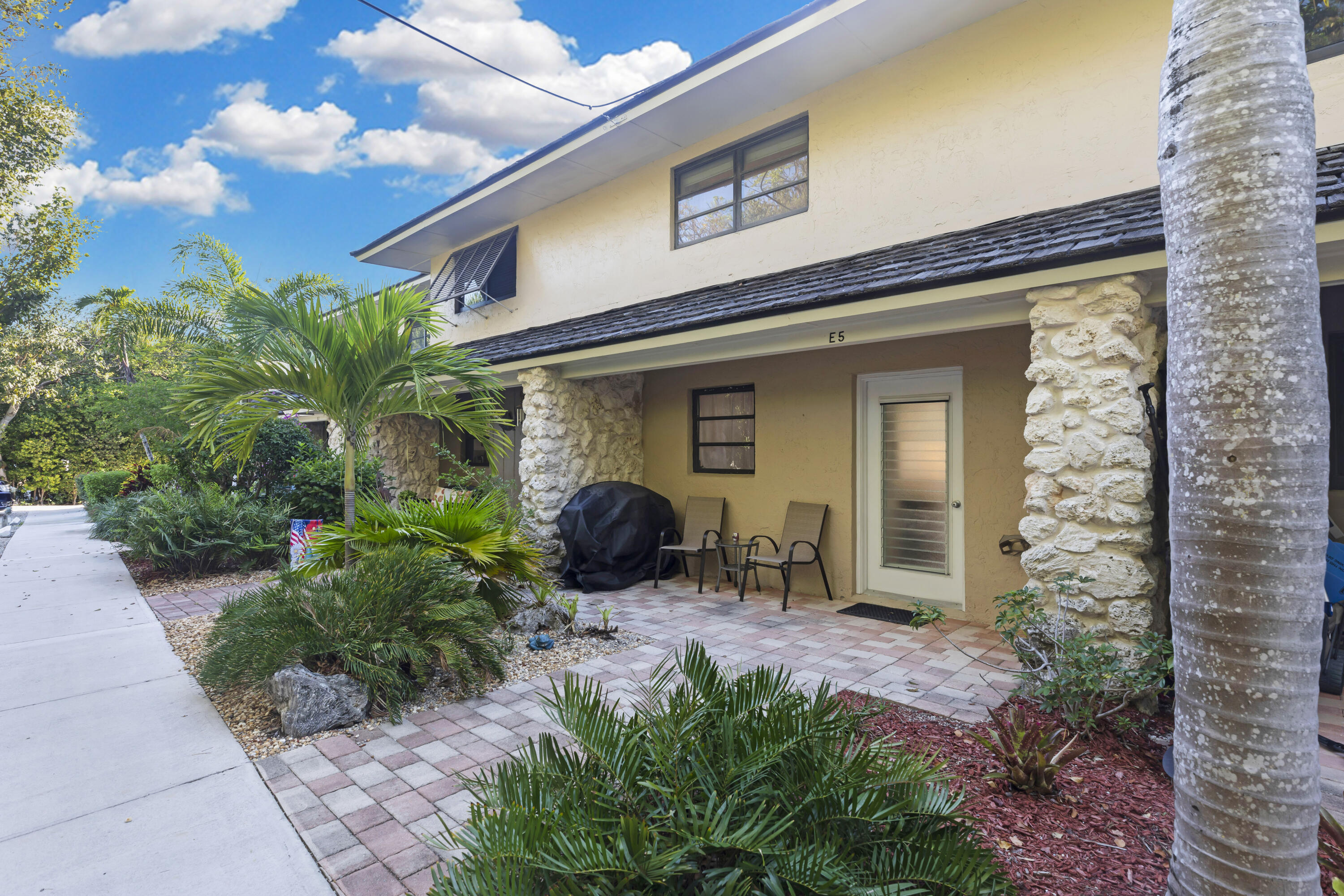 96000 Overseas Highway, Unit E5 Key Largo, FL 33037 - Photo 1 of 47 a front view of house with yard and outdoor seating