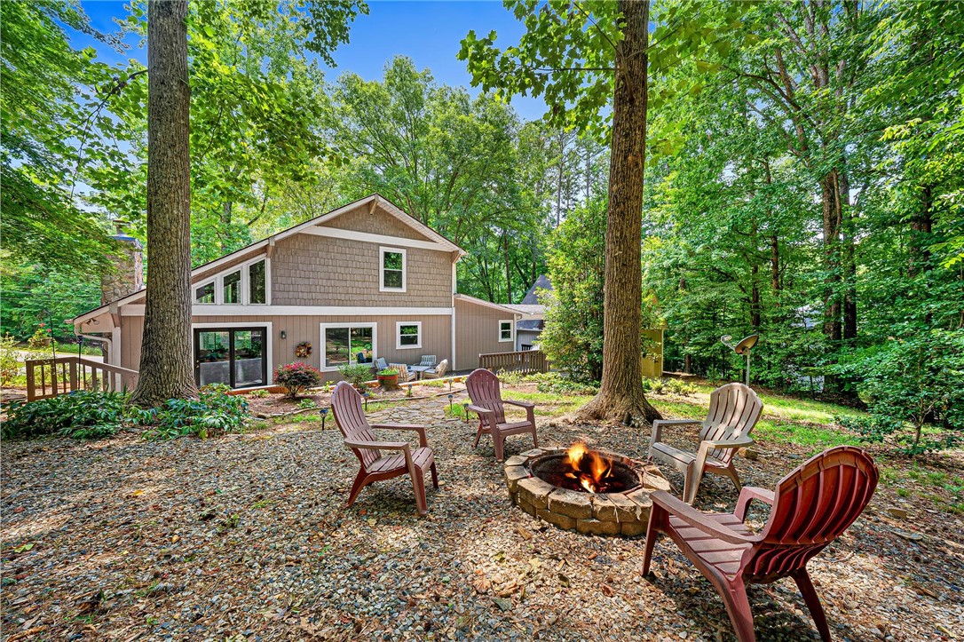 139 Tulip Lane Westminster, SC 29693 - Photo 5 of 37 A tranquil backyard oasis features a cozy fire pit and ample seating for gathering with loved ones.