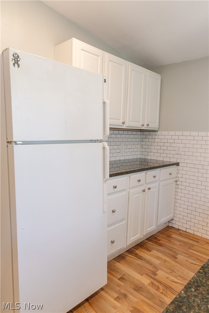 180 South Ridge Road West Geneva, OH 44041 - Photo 6 of 40 Kitchen with white cabinets, white fridge, dark stone counters, and light wood-type flooring