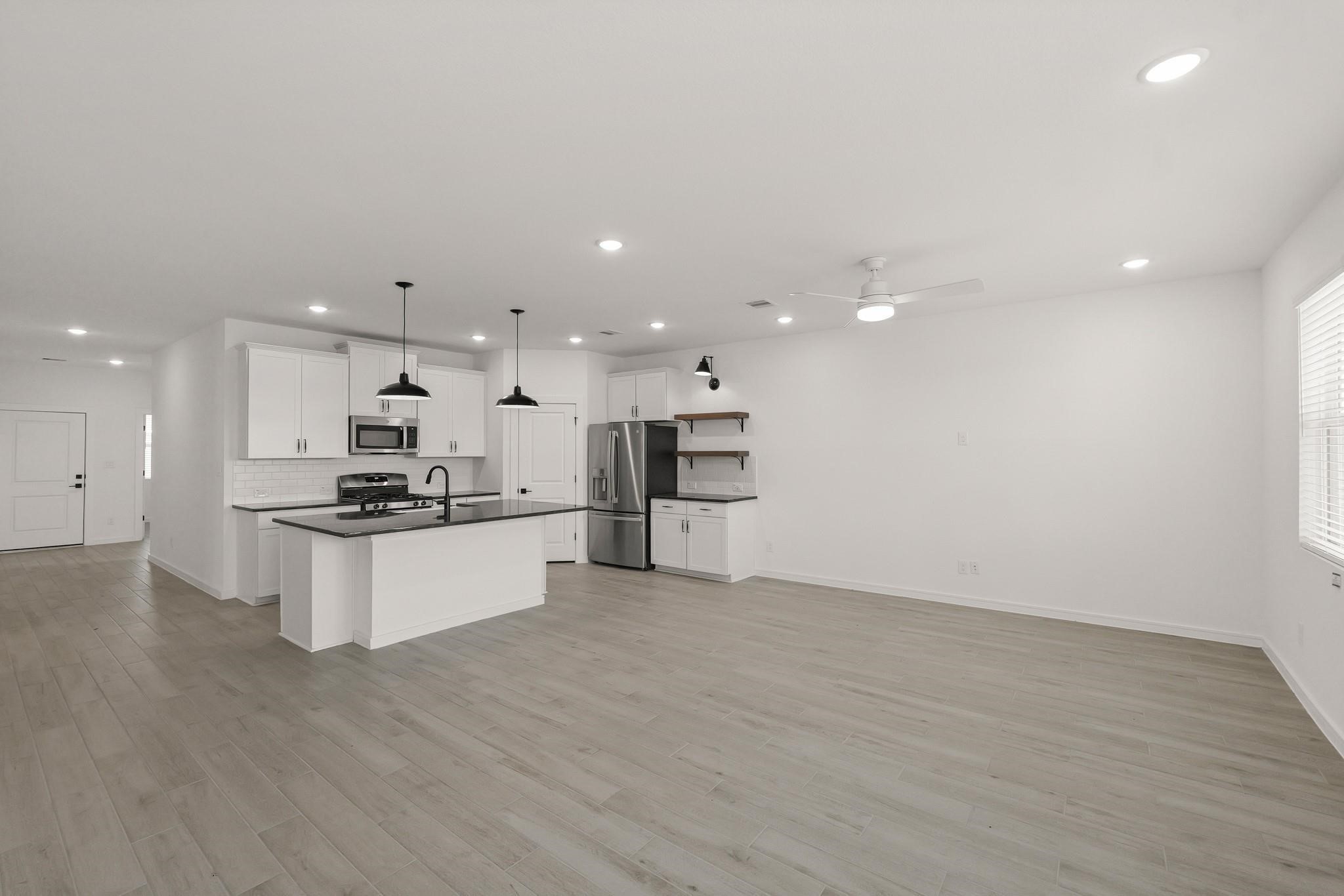 7815 Jade Crest Drive Angleton, TX 77515 - Photo 7 of 31 a large kitchen with stainless steel appliances kitchen island a large counter top and a stove top oven