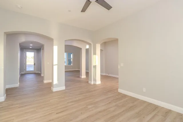 a view of a hallway with wooden floor and chandelier