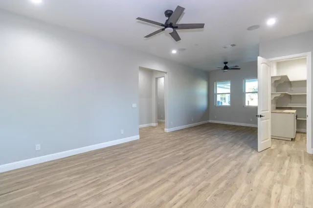 an empty room with wooden floor and windows