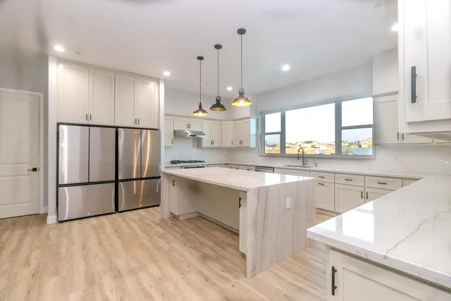 a large kitchen with kitchen island a sink stainless steel appliances and cabinets