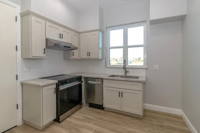 a kitchen with stainless steel appliances granite countertop a sink and a stove