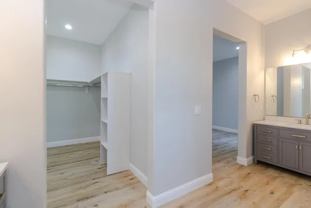 a view of an empty room with wooden floor and cabinet