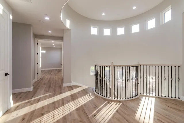 a view of a hallway with wooden floor and staircase