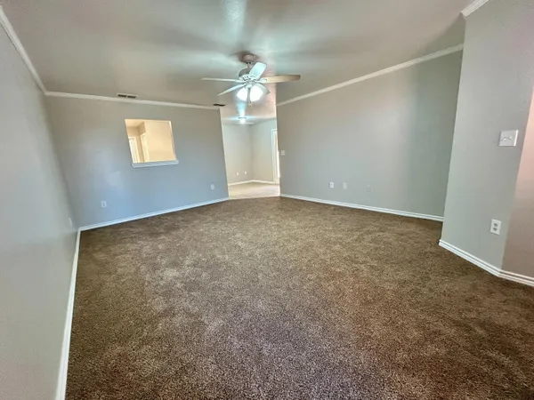 en empty room with windows and ceiling fan