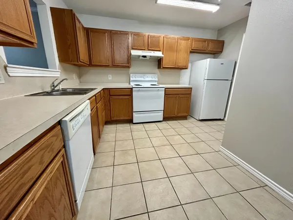 a kitchen with a sink a stove and a refrigerator