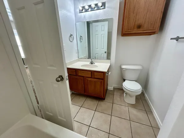 a bathroom with a toilet a sink and mirror