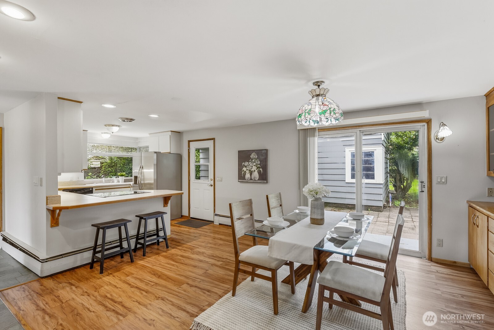 3822 Shelby Road Lynnwood, WA 98087 - Photo 10 of 40 a dining room with wooden floor and a chandelier