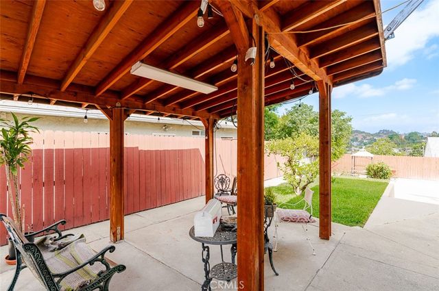 a porch with a table and chairs in front of it