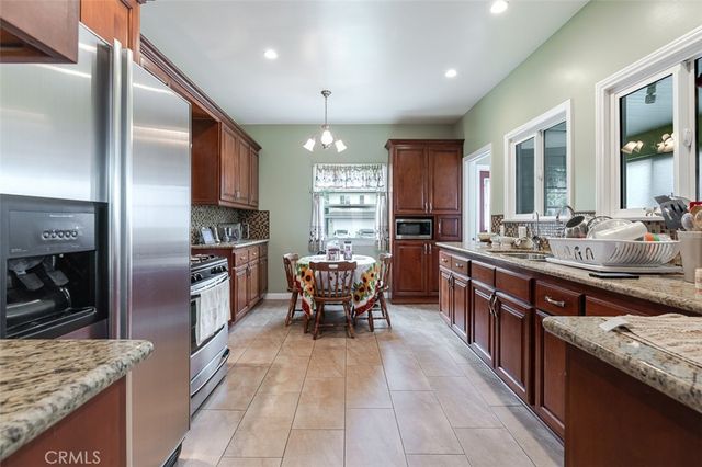 a large kitchen with stainless steel appliances kitchen island granite countertop a large counter top cabinets and stainless steel appliances