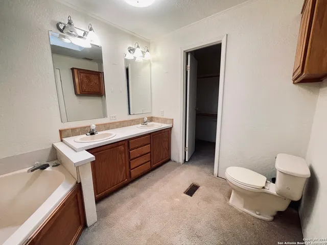 a bathroom with a double vanity sink toilet and mirror