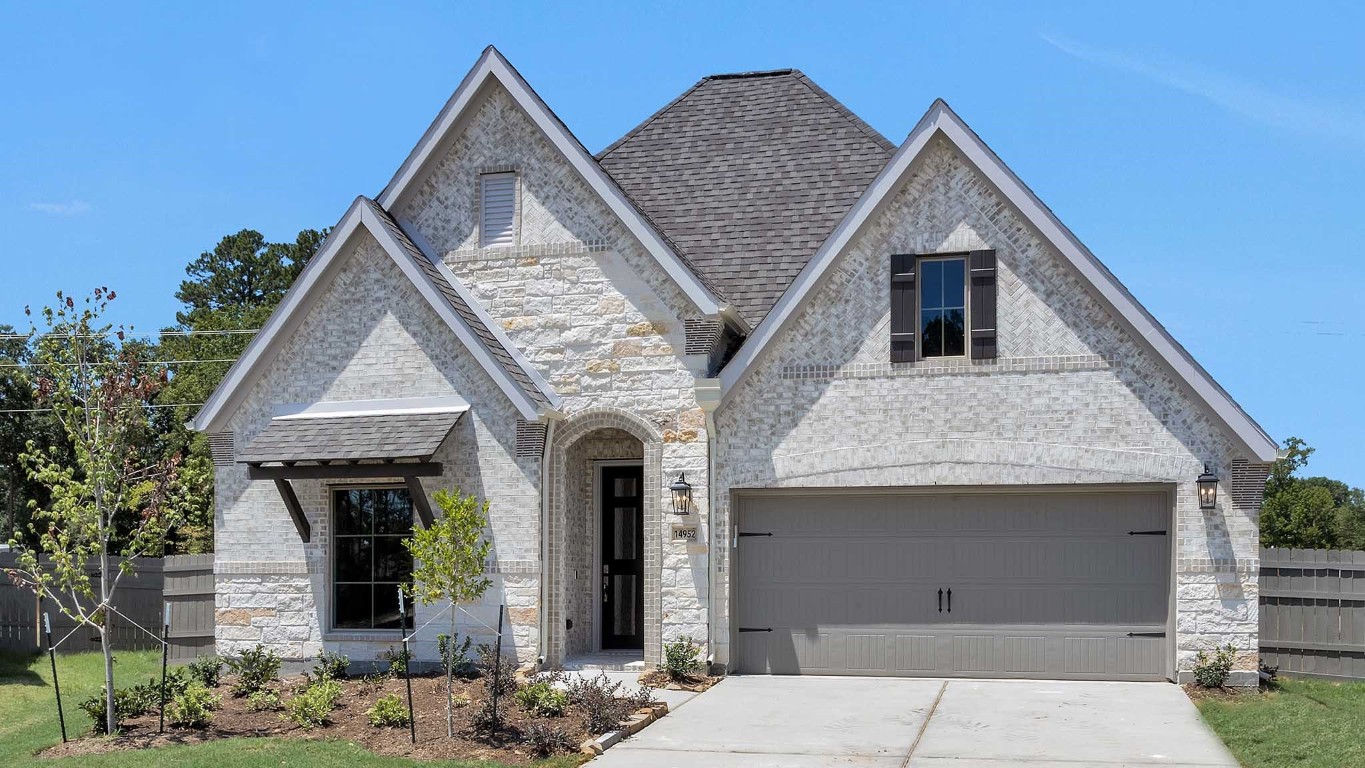 14952 Bright Berry Drive Conroe, TX 77302 - Photo 1 of 19 a front view of a house with garden