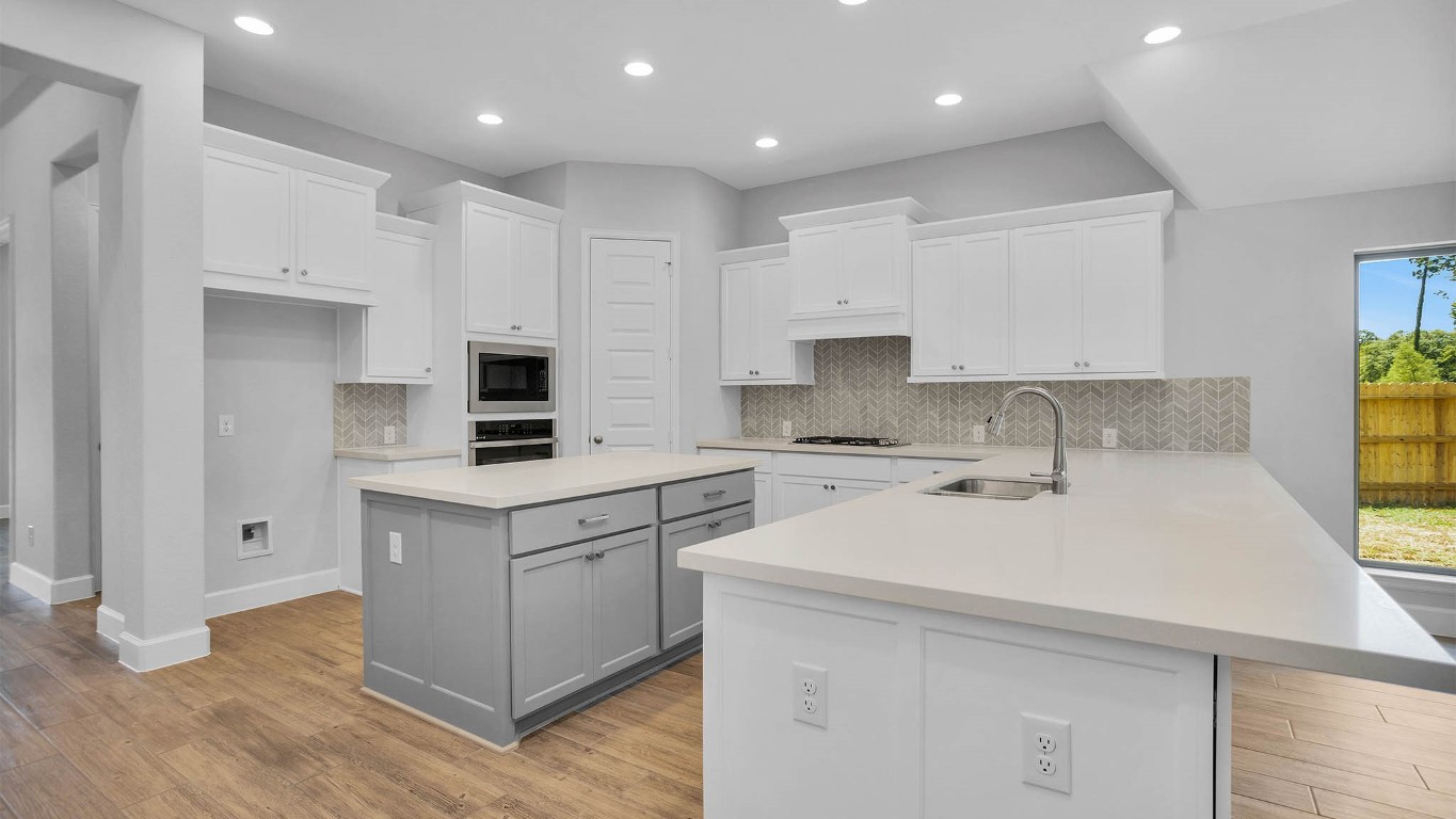 14952 Bright Berry Drive Conroe, TX 77302 - Photo 2 of 19 a kitchen with kitchen island white cabinets appliances and a window