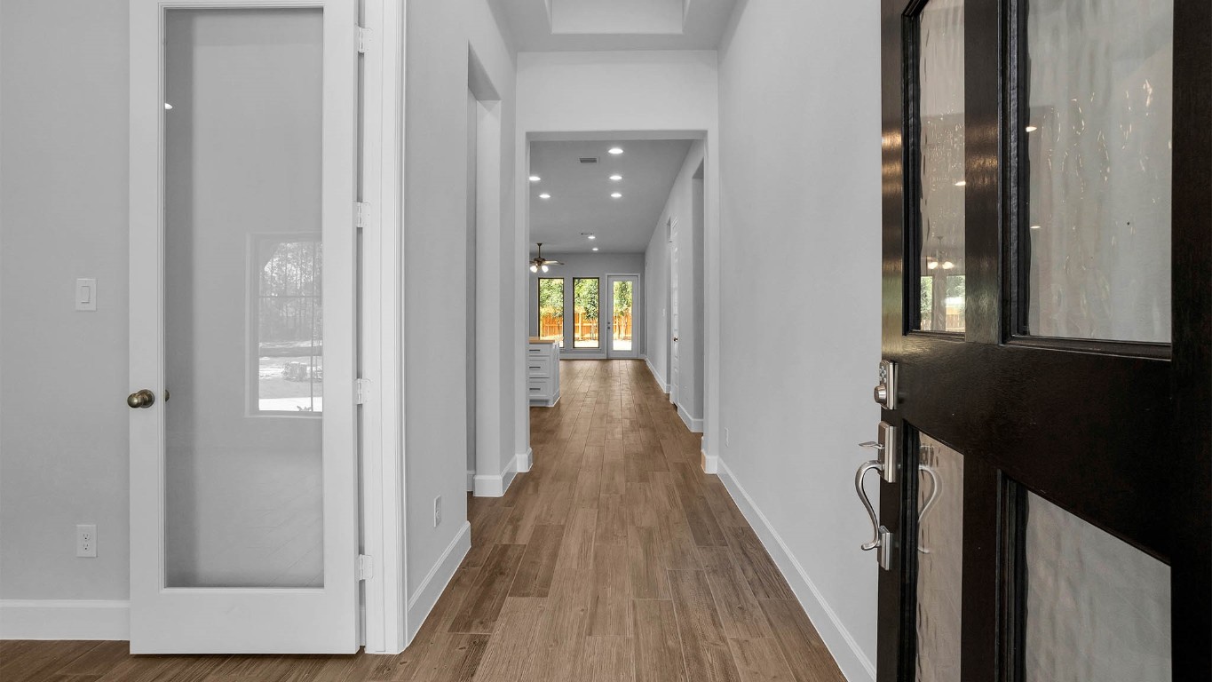 14952 Bright Berry Drive Conroe, TX 77302 - Photo 8 of 19 a view of a hallway with wooden floor and staircase