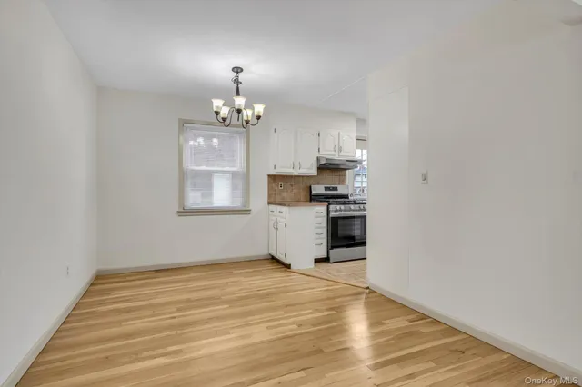 a view of a kitchen with wooden floor and a window